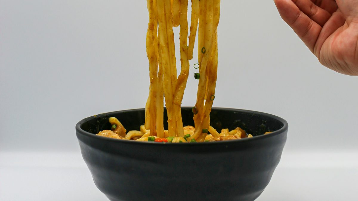 カレーうどんを箸で持ち上げたイメージ写真